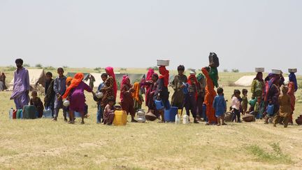 Des personnes déplacées attendent de recevoir de l'eau potable d'un camion-citerne&nbsp;à Hyderabad, dans la province du Sindh, le 9 septembre 2022. (AKRAM SHAHID / AFP)