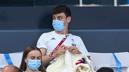 Le plongeur britannique Tom Daley en pleine séance de tricot dans les gradins des Jeux olympiques, le 2 août 2021 au Centre aquatique de Tokyo (Japon). (STEPHEN MCCARTHY / SPORTSFILE / GETTY IMAGES)