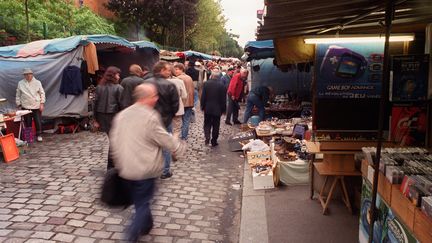 Des personnes se prom&egrave;nent dans les Puces de Saint-Ouen (Seine-Saint-Denis) le 14 octobre 2001. (MARTIN BUREAU / AFP)