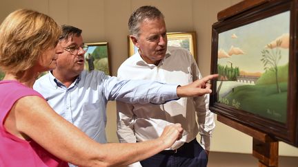 Antoinette Le Falher, directrice du musée d'art naïf de Laval avec Didier Pillon, adjoint au maire et François Zocchetto, maire de Laval, devant  le tableau "Paysage avec pêcheur" d'Henri Rousseau, le 29 août 2017
 (JEAN-FRANCOIS MONIER / AFP)