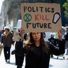 Une jeune manifestante tient une pencarte sur laquelle on lit "les politiques tuent le future", lors d'une marche du collectif Extinction Rébellion, à Toulouse (Haute-Garonne), le 26 mars 2022. (ALAIN PITTON / NURPHOTO / AFP)