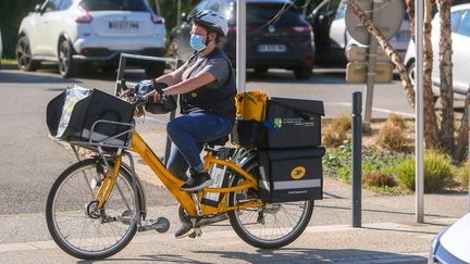 Une factrice sur son vélo dans les rues de Valence (Drôme), le 19 mars 2020. (NICOLAS GUYONNET / HANS LUCAS)