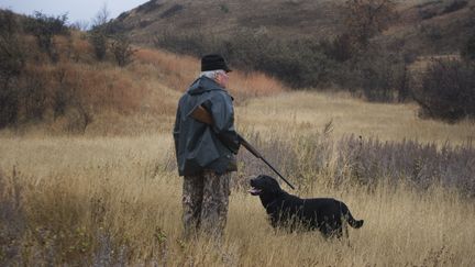 Un chasseur et son chien dans la campagne. (MIKE KEMP / CORBIS HISTORICAL/ GETTYIMAGES)