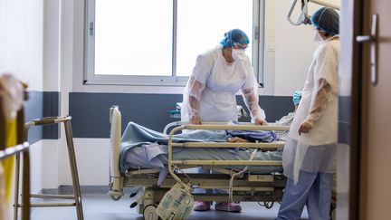 Des infirmières au chevet d'un patient atteint du Covid-19, le 3 décembre 2020, à Limoges (Haute-Vienne). (BURGER / PHANIE / AFP)