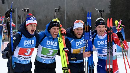 (De gauche à droite) Eric Perrot, Quentin Fillon Maillet, Antonin Guigonnat et Fabien Claude célèbrent leur troisième place sur le podium du relais hommes, à Ruhpolding (Allemagne), le 13 janvier 2023. (CHRISTOF STACHE / AFP)