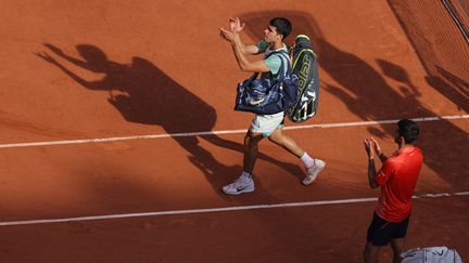 Carlos Alcaraz sort vaincu du court Philippe-Chatrier sous les applaudissements du public et de Novak Djokovic en demi-finales de Roland-Garros. (THOMAS SAMSON / AFP)