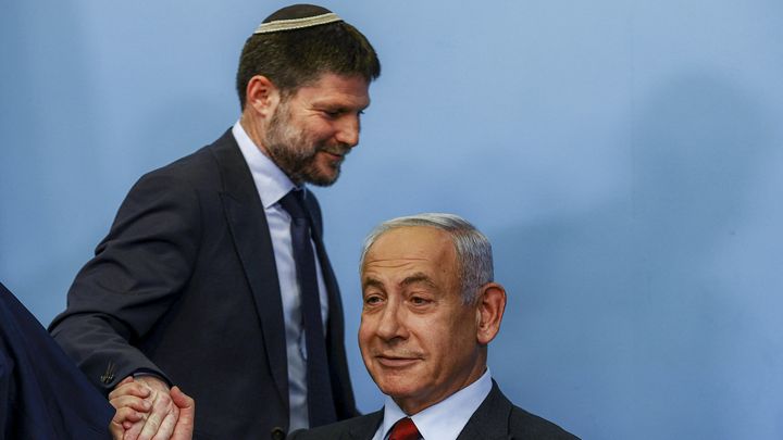 Le ministre israélien des Finances, Bezalel Smotrich, serre la main de Benyamin Nétanyahou lors d'une conférence de presse à Jérusalement, le 25 janvier 2023. (RONEN ZVULUN / AFP)