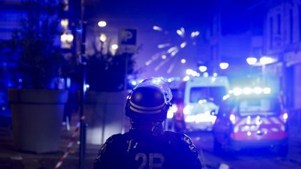 Un policier dans un quartier de Roubaix fait face à des tirs de mortiers, le 30 juin 2023. (KENZO TRIBOUILLARD / AFP)