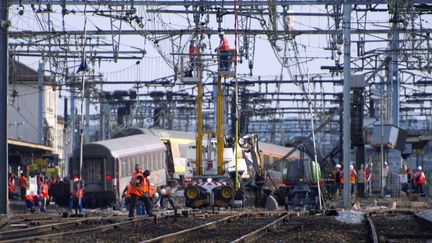 Secouristes et enqu&ecirc;teurs s'affairent apr&egrave;s le d&eacute;raillement d'un train&nbsp;Paris-Limoges en gare de Br&eacute;tigny-sur-Orge (Essonne), qui a fait sept morts et 26 bless&eacute;s, le 12 juillet 2013.&nbsp; (ETIENNE LAURENT / MAXPPP)