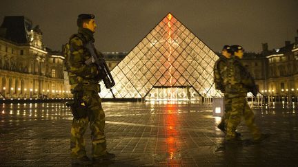 Trois militaires du plan Vigipirate Alerte Attentat passent devant la pyramide du Louvre à Paris
 (JOEL SAGET / AFP)