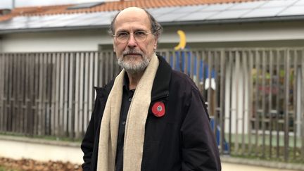 Gérard Bolet, vice-président de la communauté de communes Sicoval, pose devant des panneaux photovolatïques installés sur un bâtiment public. (MATTHIEU MONDOLONI / RADIO FRANCE)