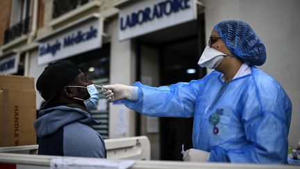 Un homme effectue un test PCR devant un laboratoire à Paris, le 29 août 2020. (CHRISTOPHE ARCHAMBAULT / AFP)