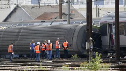 Des enqu&ecirc;teurs inspectent le train qui a d&eacute;raill&eacute; &agrave;&nbsp;Br&eacute;tigny-sur-Orge (Essonne), au lendemain de l'accident,&nbsp;le 13 juillet 2013. (KENZO TRIBOUILLARD / AFP)