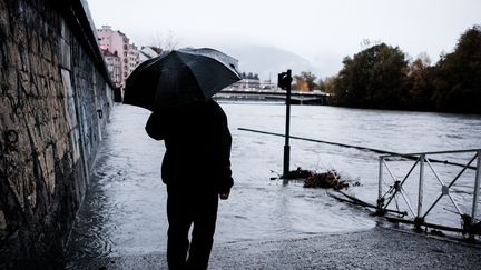 Un homme observe la rivière de l'Isère, le 12 janvier 2023 à Grenoble (Isère). (BENOIT PAVAN / HANS LUCAS / AFP)