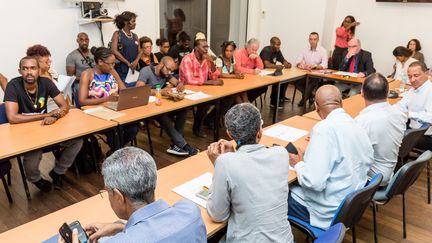 Des représentants du collectif Pou Lagwiyann Dekolé, des élus et le préfet de Guyane, réunis pour passer en revue les élements de l'accord finalement signé le 21 avril 2017 à Cayenne (JODY AMIET / AFP)