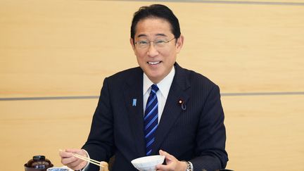 Le Premier ministre japonais, Fumio Kishida, pose alors qu'il mange des fruits de mer de la préfecture de Fukushima, le 30 août 2023, à Tokyo. (JIJI PRESS / CABINET PUBLIC RELATIONS OFFICE / AFP)