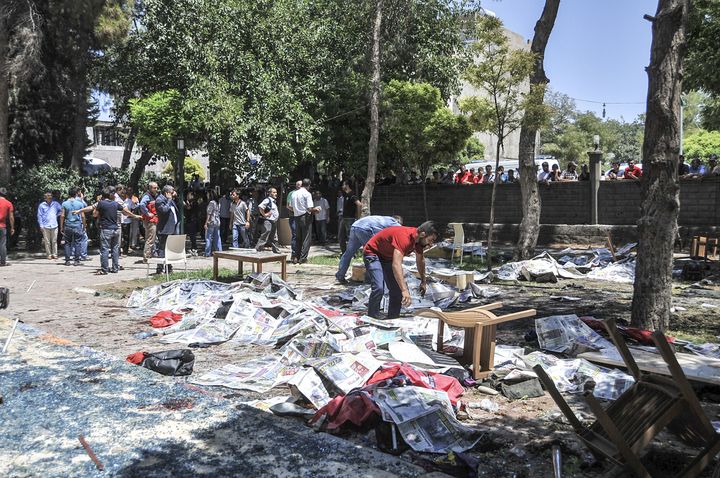 Les corps des victimes ont &eacute;t&eacute; recouverts de journaux apr&egrave;s l'explosion qui a eu lieu dans le jardin d'un centre culturel de Suru&ccedil; (Turquie), le 20 juillet 2015.&nbsp; (RAUF MALTAS / ANADOLU AGENCY / AFP)