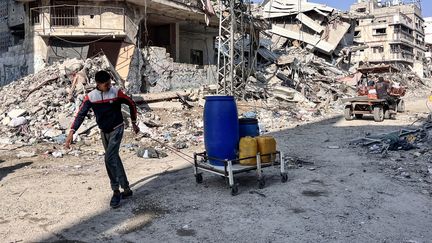 Un jeune Palestinien transportent des conteneurs remplis d'eau potable, dans le nord de la bande de Gaza, le 3 novembre 2024. (AFP)