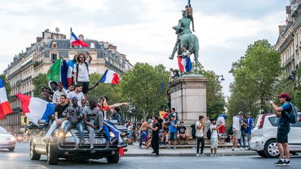 Des supporters fêtent la victoire de la France en Coupe du monde de football, le 15 juillet 2018 à Paris.&nbsp; (SIMON GUILLEMIN / HANS LUCAS / AFP)