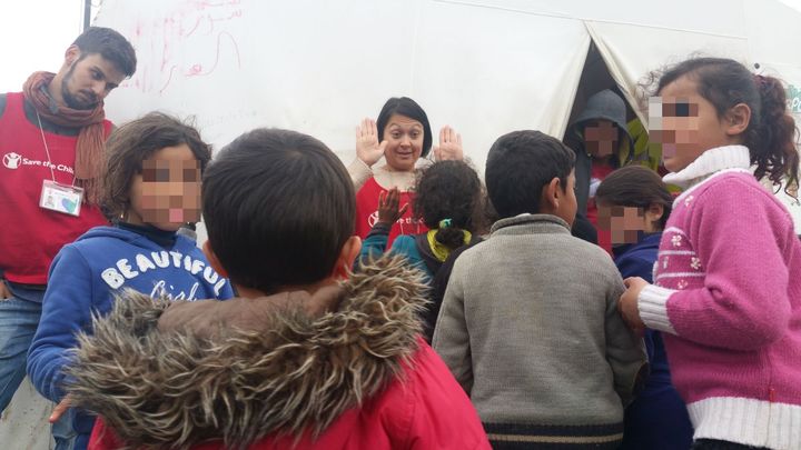 Une volontaire de l'ONG Save The Children joue avec des enfants au camp de migrants d'Idomeni (Grèe), le 16 mars 2016. (LOUIS SAN / FRANCETV INFO)