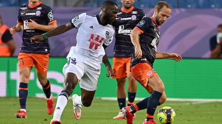 Le milieu de terrain de Bordeaux Junior Onana (C) se bat pour le ballon avec l'attaquant français de Montpellier Valère Germain (R) lors du match de football de L1 française entre Montpellier (MHSC) et Bordeaux (FCGB), au stade de La Mosson à Montpellier, le 22 septembre 2021. (PASCAL GUYOT / AFP)