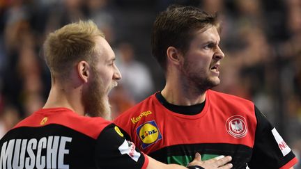 Les joueurs allemands&nbsp;Matthias Musche&nbsp;et Fabian Bähm se congratulent lors du match de poule victorieux de leur équipe face à la Croatie en poules du Mondial de handball, lundi 21 janvier, à Cologne (Allemagne). (FEDERICO GAMBARINI / DPA)