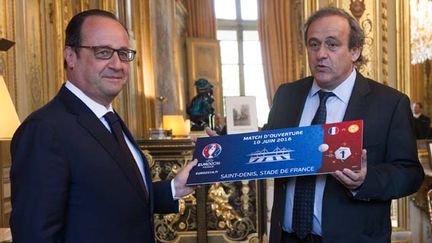  (En marge de la conférence de presse, Michel Platini a remis ce mercredi à François Hollande un billet symbolique pour le match d'ouverture de l'Euro 2016 en France © MaxPPP)