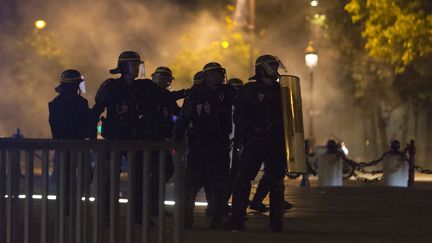 Des CRS sur l'avenue des Champs-Elysées, à Paris, après la victoire de la France contre l'Allemagne à l'Euro&nbsp;de football,&nbsp;le 7 juillet 2016. (GEOFFROY VAN DER HASSELT / AFP)