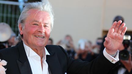 L'acteur Alain Delon salue le public lors de la mont&eacute;e des marches au Festival de Cannes, le 26 mai 2013. (LOIC VENANCE / AFP)