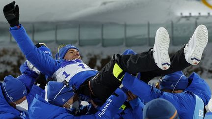 L'équipe de France fête le sacre olympique de Quentin Fillon Maillet sur l'individuel en biathlon, mardi 8 février, aux JO de Pékin. (ODD ANDERSEN / AFP)