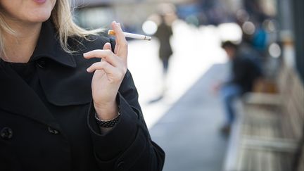 Une femme fume dans la rue le 4 mars 2015. (AMELIE-BENOIST / BSIP)