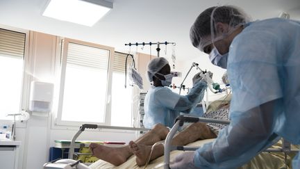 Le personnel de l'hôpital de Colombes (Hauts-de-Seine) s'occupe d'un patient atteint du Covid-19, en novembre 2020. (ALAIN JOCARD / AFP)