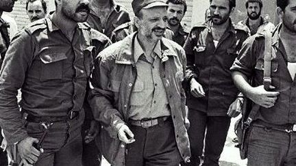 Le leader palestinien Yasser Arafat porte une Kalachnikov lors de l'invasion du Liban par l'armée israélienne en 1982. Cette arme ne suffira pas pour empêcher les Israéliens de prendre Beyrouth et d'expulser les Palestiniens du Liban. (RAMZI HAIDAR / AFP)