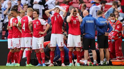 Les Danois réunis autour de Christian Eriksen après son&nbsp;arrêt cardiaque sur le terrain, lors de Danemark - Finlande à l'Euro, samedi 12 juin 2021. (FRIEDEMANN VOGEL / POOL)