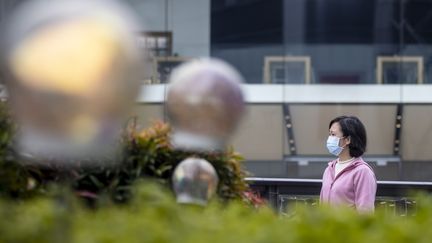 Une femme porte un masque dans un centre commercial désert, à Guangzhou, en Chine,&nbsp;le 5 février 2020. (ALEX PLAVEVSKI / EPA)