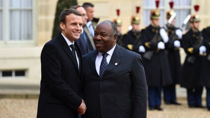 Emmnauel Macron et Ali Bongo, le président du Gabon, sur le parvis de l'Élysée le 12 décembre 2017 (photo d'illustration). (ALAIN JOCARD / AFP)