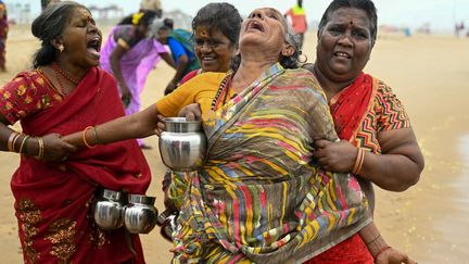 Une femme pleure en effectuant des rituels, toujours sur la plage de Pattinapakkam. (R.SATISH BABU / AFP)