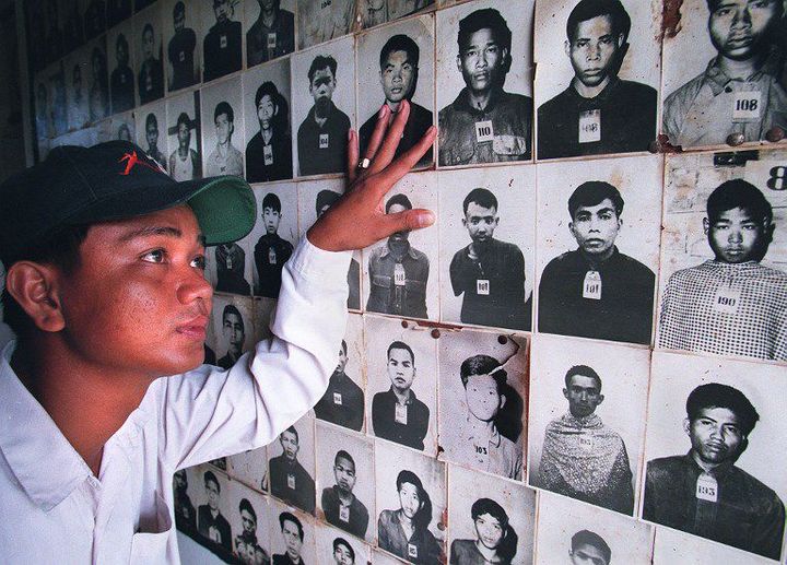 Eng Rottha, 28 ans, regarde des photos de personnes torturées et massacrées par des Khmers rouges dans l'ancienne prison de Tuol Sleng à Phnom Penh, devenue un musée. Un lieu de supplice où sont morts 12.380 adultes et enfants. Dont le propre père d'Eng Rottha.  (AFP - ROB ELLIOTT)