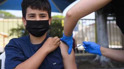 Un adolescent de 13 ans reçoit une première dose du vaccin Pfizer à Los Angeles, en Californie, le 14 mai 2021. (PATRICK T. FALLON / AFP)