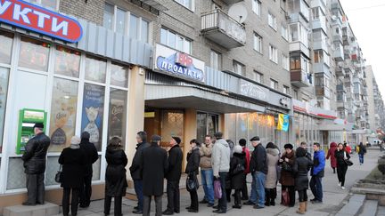 A Lviv (ville de l'ouest de l'Ukraine), comme &agrave; Kiev,&nbsp;les habitants retirent&nbsp;le maximum d'argent possible aux distributeurs bancaires.&nbsp; (YURIY DYACHYSHYN / AFP)