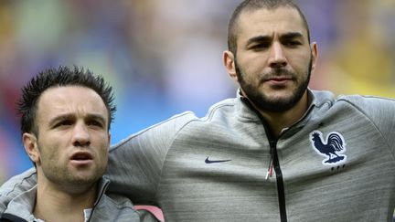 Mathieu Valbuena (à gauche) et Karim Benzema (à droite) écoutant l'hymne national&nbsp;lors du huitième de finale de la Coupe du monde entre la France et le Nigeria à Brasilia (Brésil),&nbsp;le 30 juin 2014. (FRANCK FIFE / AFP)