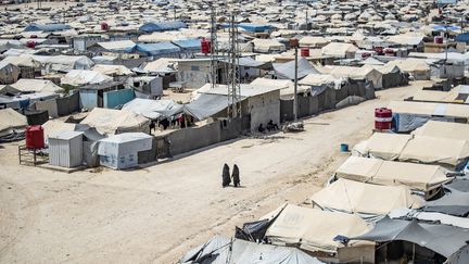 Des femmes marchent dans un camp de personnes affiliées au groupe État islamique (EI) dans le nord de la Syrie, le 2 août 2021. Photo d'illustration. (DELIL SOULEIMAN / AFP)