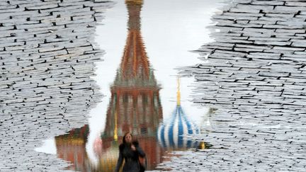 La cath&eacute;drale Saint-Basile-le-Bienheureux de Moscou se refl&egrave;te dans une flaque d'eau sur la place Rouge &agrave; Moscou (Russie), le 29 novembre 2013. (KIRILL KUDRYAVTSEV / AFP)