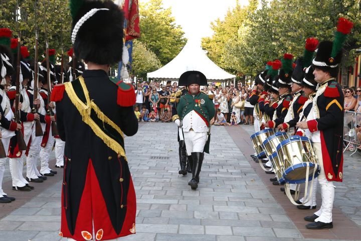 Un homme déguisé en Napoléon s'en vient embrasser le drapeau français le 9 août 2018 à Ajaccio. (PASCAL POCHARD-CASABIANCA / AFP)