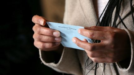 A person holds an envelope before going to vote. (NICOLAS VALLAURI / MAXPPP)