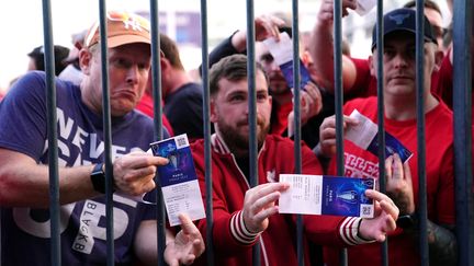 Des supporters de Liverpool munis de billets devant les grilles du Stade de France, à Saint-Denis,&nbsp;lors de la finale de la Ligue des champions face au Real Madrid, le 28 mai 2022. (ADAM DAVY / MAXPPP)