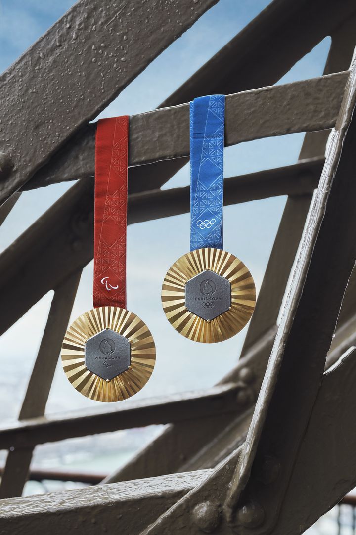 Les médailles d'or paralympique (ruban rouge) et olympique (ruban bleu) accrochées à la tour Eiffel. (© Paris 2024)