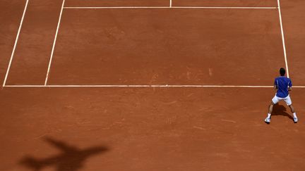 L'ombre de l'avion-cam&eacute;ra install&eacute; &agrave; Roland-Garros traverse le court lors du match opposant le Serbe Novak Djokovic (photo) &agrave; l'Allemand Philipp Kohlschreiber, Paris, le 3 juin 2013. (MARTIN BUREAU / AFP)