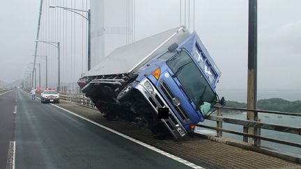 Un camion&nbsp;encastré sur un pont de Sakaden&nbsp;(Japon), le 4 septembre 2018.&nbsp; (JIJI PRESS / KAGAWA PREFECTURAL POLICE / AFP)