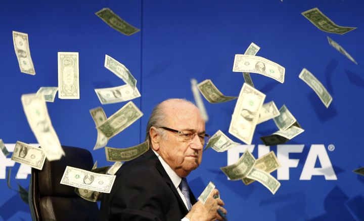 Le président de la Fifa, Sepp Blatter, couvert de faux billets lancés par un humoriste britannique, le&nbsp;20 juillet 2015, à Zurich (Suisse), avant une conférence de presse. (ARND WIEGMANN / REUTERS)